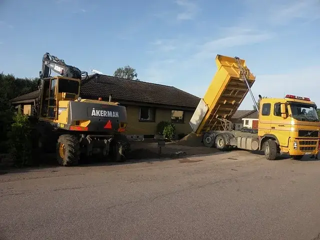 Grävmaskin och lastbil på plats för ett markarbete