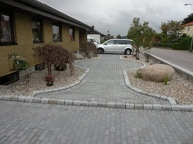 Färdig uppfart i marksten med kantsten och planteringar