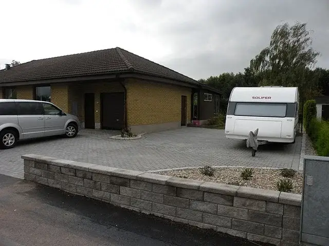 Mur och grusad planteringsyta vid uppfarten