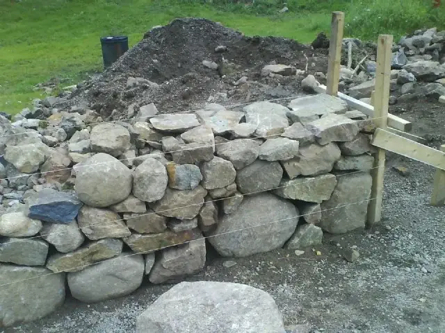 Mur av natursten under uppbyggnad