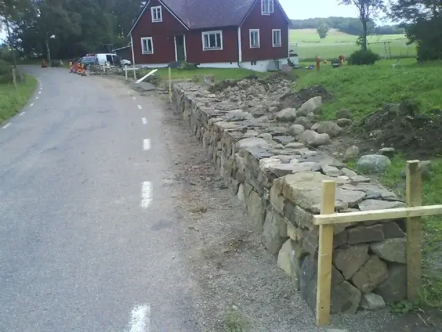 Färdig mur av natursten längs en väg