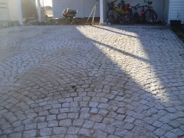 Gårdsplan i gatsten framför ett hus