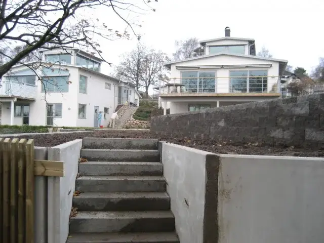 Trappa genom stödmuren upp mot huset